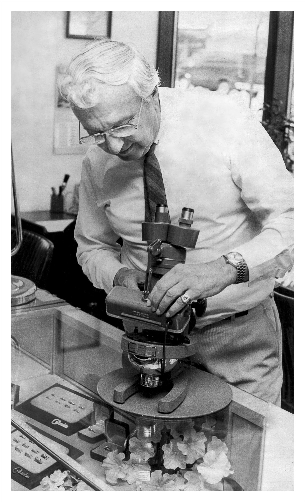 John Saxon examining a piece under a jeweler's microscope
